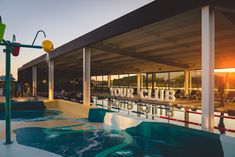 an empty swimming pool with the words your club painted on it's side at sunset