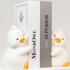 two white bears sitting next to each other in front of a bookcase with the words monopoly on it