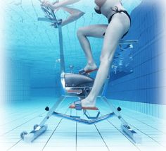 a woman in a bathing suit is on a stationary exercise bike under the water,