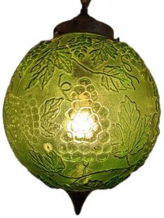 a green glass ornament hanging from a hook