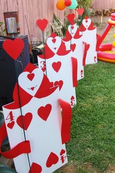 the lawn is decorated with red and white playing cards for valentine's day party