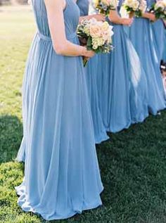 the bridesmaids are wearing blue dresses and holding bouquets