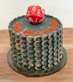 a birthday cake with a red dice on top