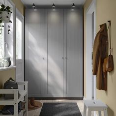 an empty hallway with white walls and wooden flooring next to a large gray door