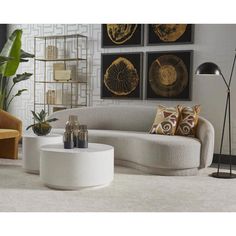 a living room filled with furniture next to a wall mounted planter and pictures on the wall