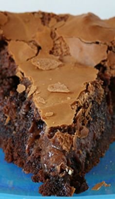 a piece of chocolate gooey cake on a blue plate with the title above it