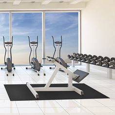 there are many treadmills and exercise machines in this room with large windows looking out onto the ocean