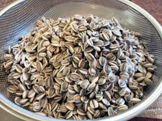 a metal bowl filled with seeds on top of a table