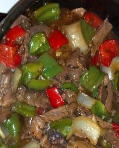 a skillet filled with beef, peppers and onions