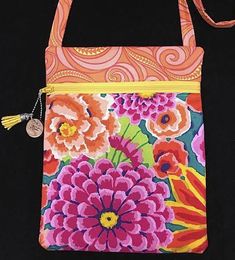 an orange and pink flowered purse on a black background