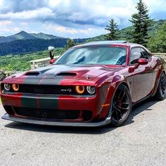 a red and black car parked on the side of a road