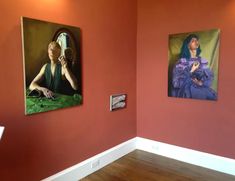 two paintings hang on the wall next to each other in a room with wood floors