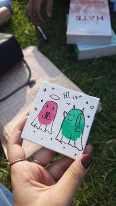 a person holding up a small magnet with two different animals on it's side