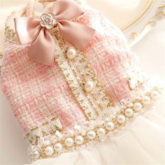 a pink and white purse with pearls on it