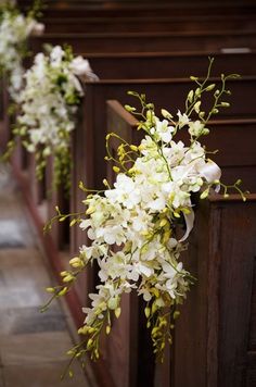 white flowers are in the pews of a church