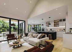 a living room filled with furniture next to a kitchen and an open concept dining area