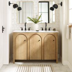 a bathroom with two sinks and mirrors on the wall