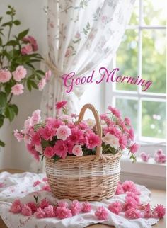 a basket filled with pink flowers sitting on top of a table next to a window