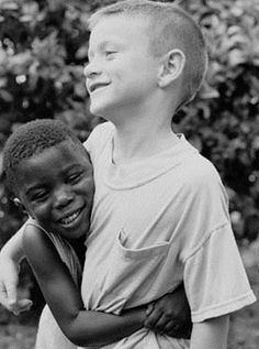 two young boys hugging each other in black and white