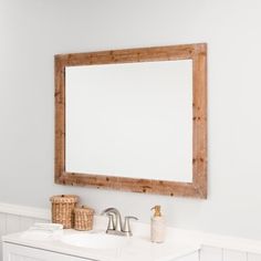 a bathroom with a sink, mirror and towel dispenser on the wall