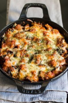 a casserole with meat and cheese in a black skillet on a table