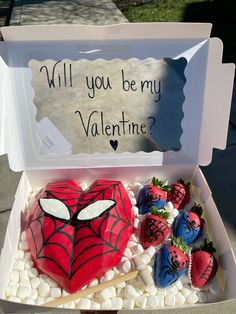 a heart shaped cake with strawberries in the shape of a spiderman on it