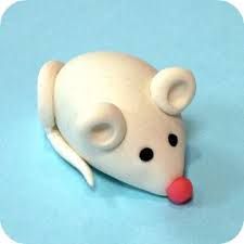 a white toy mouse laying on top of a blue surface