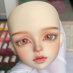 an image of a doll with big eyes wearing a headscarf and looking at the camera