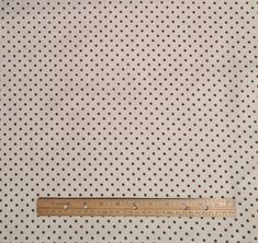 a ruler is on top of a sheet of polka dot fabric