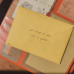 a piece of yellow paper with writing on it sitting on top of a wooden table