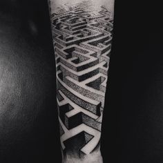 a black and white photo of a man's arm with a maze tattoo on it