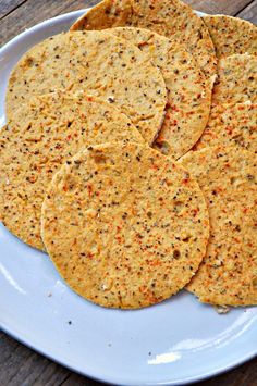 four tortillas on a white plate sitting on a wooden table