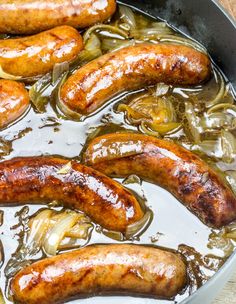 sausages and onions are cooking in a pan