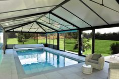 an indoor swimming pool surrounded by glass walls