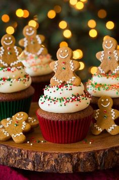 gingerbread cupcakes decorated with icing and sprinkles on a wooden platter