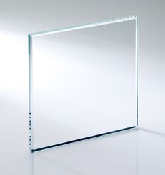 an empty square glass plate on a white surface with reflections from the light behind it