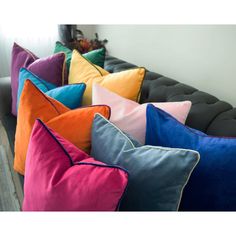 a group of colorful pillows sitting on top of a couch