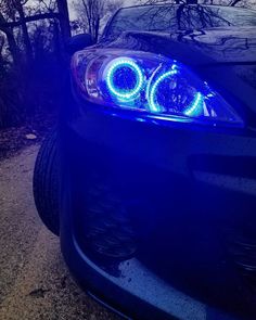 the front end of a black car with blue lights