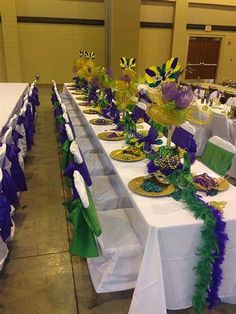 the tables are set up with purple and green decorations