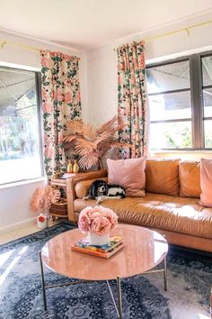 a living room filled with furniture and flowers on the window sill next to a couch