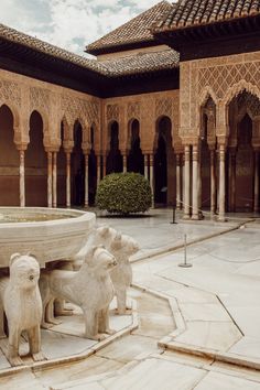 an ornate courtyard with fountain and statues in it