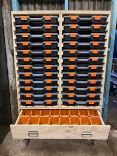 a large wooden box with many drawers on it's sides and an orange drawer in the middle