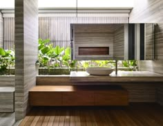 a bathroom with wooden flooring and a large mirror on the wall above the sink