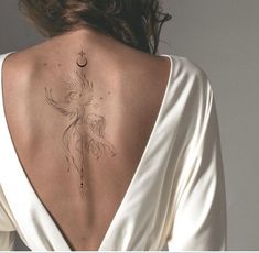 the back of a woman's neck with a bird tattoo on it