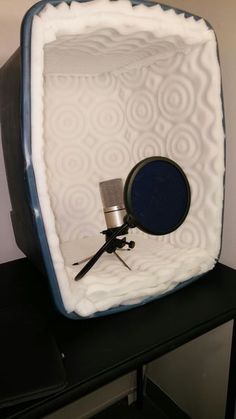 a microphone sitting on top of a black table next to a white and blue box