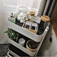 a white shelf filled with lots of items next to a window