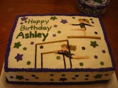 a birthday cake that is decorated with two women doing acrobatic tricks on the bars