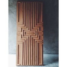 a wooden door that is sitting on the ground in front of a concrete wall and floor