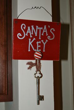 a red sign that says santa's key hanging from a hook on the wall