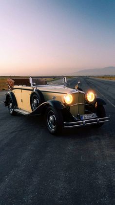 an old car is parked on the side of the road